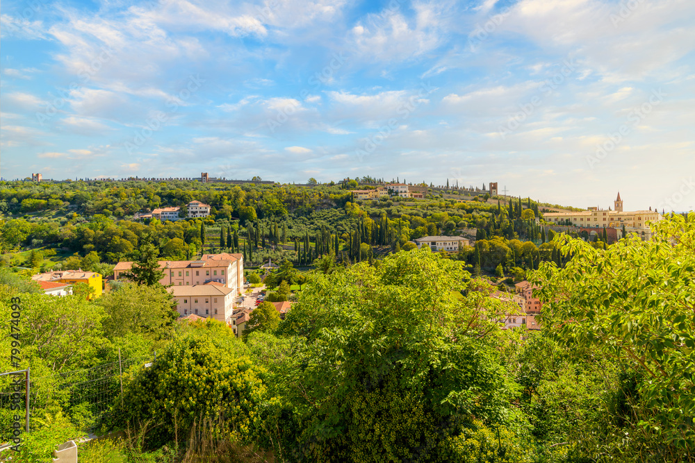 View from Castel San Pietro Hill of the panoramic path of the ancient walls of Verona rising above the green hillside and Chiesa di San Zeno in Monte church, in Verona, Italy. View from Castel San Pietro Hill of the panoramic path of the ancient walls of Verona rising above the green hillside and Chiesa di San Zeno in Monte church, in Verona, Italy.