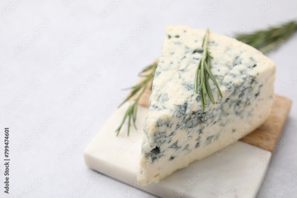 Tasty blue cheese with rosemary on light table, closeup. Space for text Tasty blue cheese with rosemary on light table, closeup. Space for text