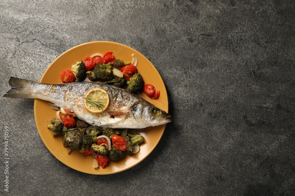 Delicious baked fish and vegetables on grey background, top view. Space for text Delicious baked fish and vegetables on grey background, top view. Space for text