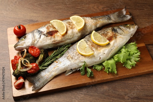Delicious baked fish and vegetables on wooden table