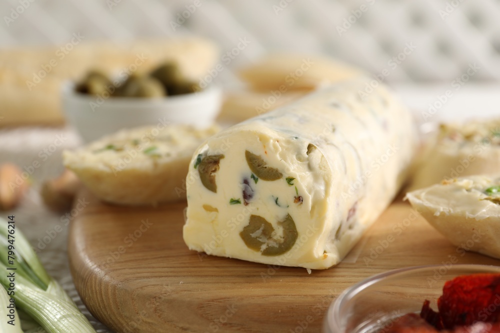 Tasty butter with olives and green onion on table, closeup