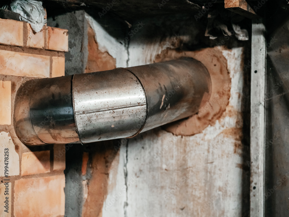 Metal wall from fire place to a chimney in an old country house. Rural life.