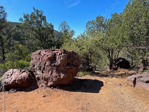 Springtime view of a large boulder beside the Gowan hiking trail in Tonto Natural Bridge State Park in Pine, Arizona with bright blue sky copy space in an area above the natural bridge. photo