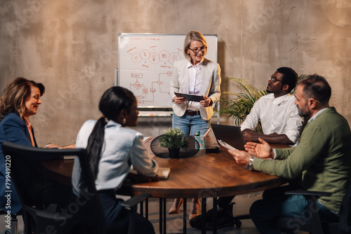 Fotografia Mature businesswoman pitching business ideas to interracial investors