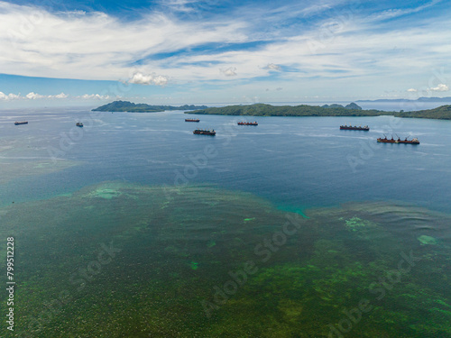 Coral reefs and turquoise water in the sea and merchant ship. Mindanao, Philippines. Seascape.