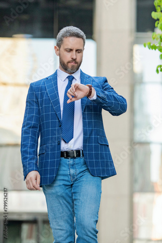 Fotografija Punctual businessman checking time outdoor