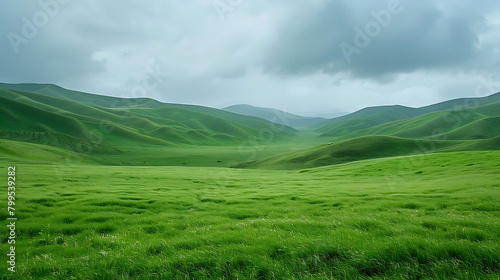 scenic vista of rolling green hills and grass under a cloudy blue sky