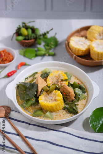 Sayur Lodeh is a vegetable dish made with coconut milk that is typical of Indonesia, especially in Central Java and DI Yogyakarta. Served in a bowl on a white table. Selective focus.