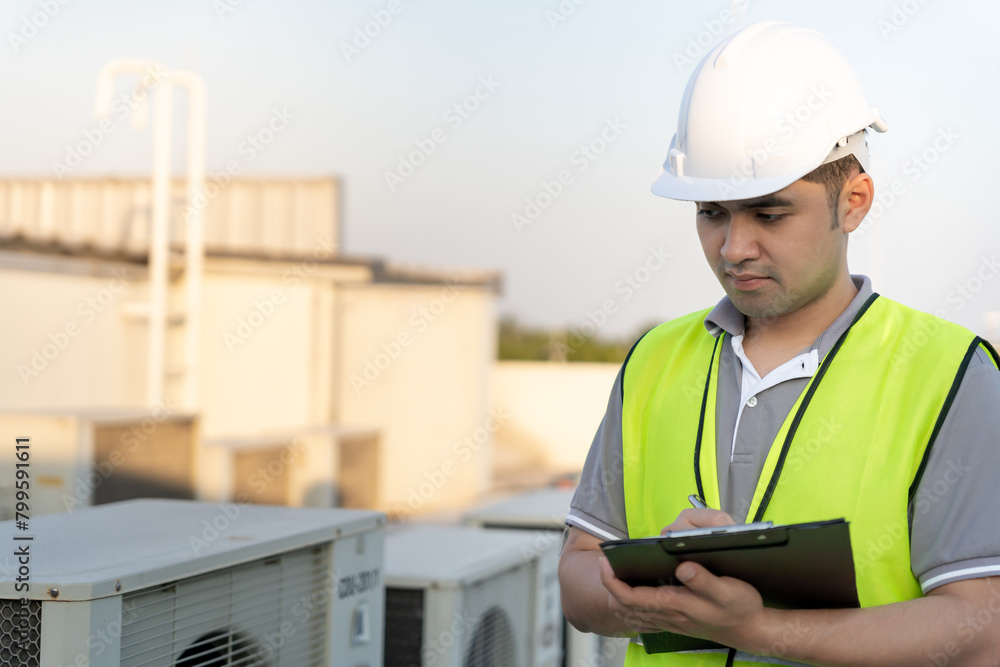 Asian maintenance engineer works on the roof of factory. contractor inspect compressor system and plans installation of air condition systems in construction. Checklist, inspector, control Asian maintenance engineer works on the roof of factory. contractor inspect compressor system and plans installation of air condition systems in construction. Checklist, inspector, control