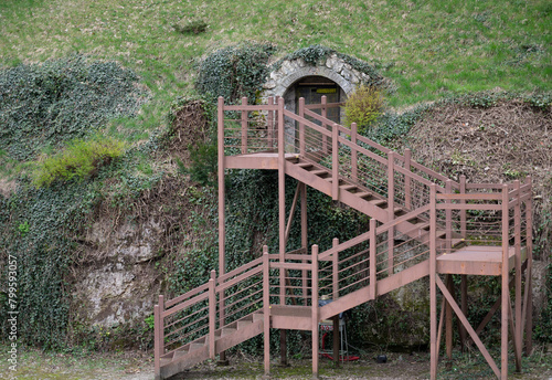 Wooden stairs leading to the underground entrance on the slope.