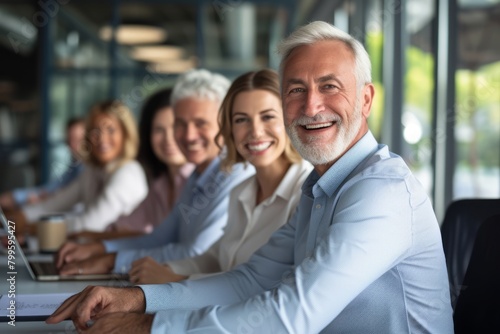 Portrait of smiling senior businessman with colleagues in the background at office