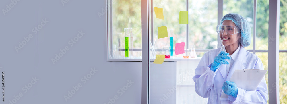Fototapeta premium Banner Asian woman scientist hand write note research in medical lab look at science microscope. Panorama biology chemistry lab. Asian Female technician laboratory using microscope with copy space
