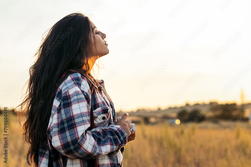 Young woman taking photos with analog camera in the field at sunset Young woman taking photos with analog camera in the field at sunset