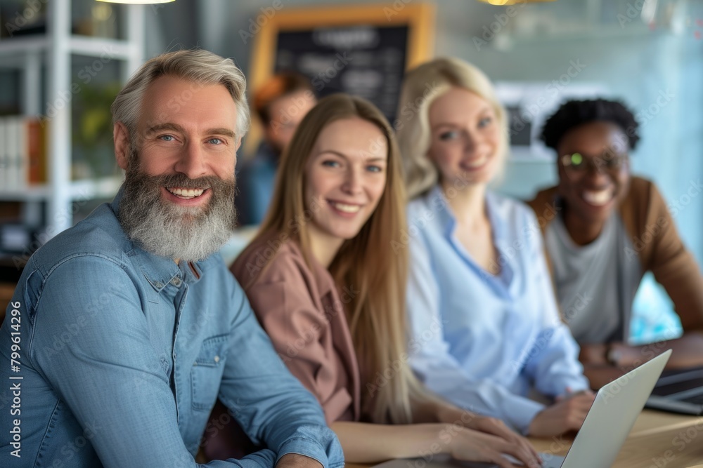 Portrait of smiling mature businessman in front of his team in office Portrait of smiling mature businessman in front of his team in office