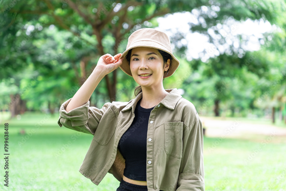 Happy asian beautiful woman smiling to camera. She feeling relaxed and refreshing while camping in the nature. Recreation and journey outdoor activity lifestyle.	