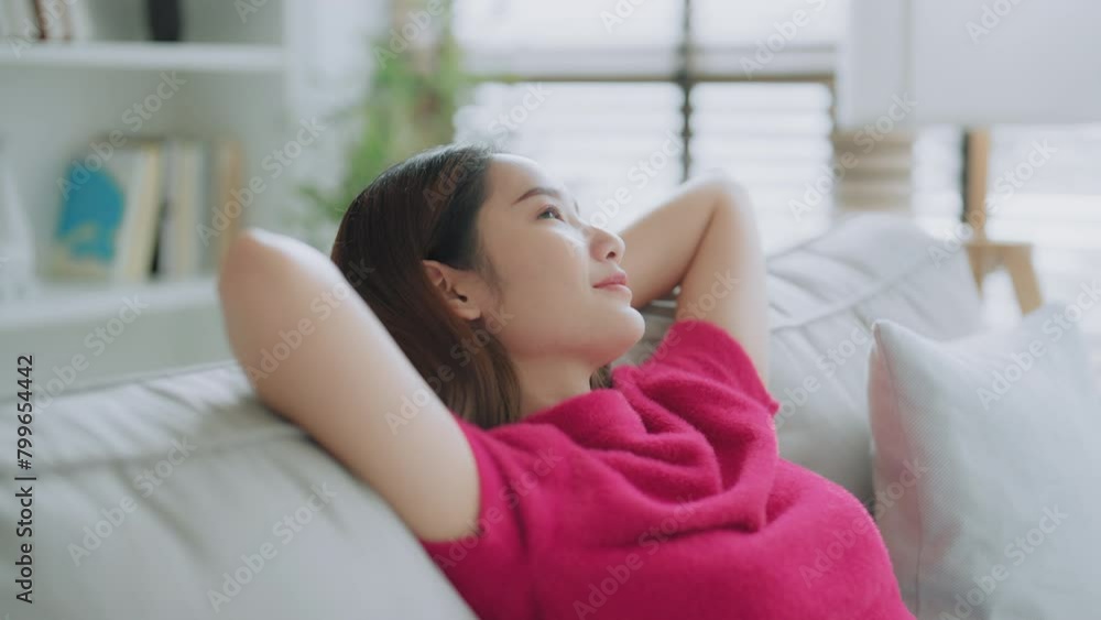 Relaxed young Asian woman enjoying rest on comfortable sofa, calm attractive girl relaxing on couch, breathing fresh air with eyes closed, meditating at home Relaxed young Asian woman enjoying rest on comfortable sofa, calm attractive girl relaxing on couch, breathing fresh air with eyes closed, meditating at home