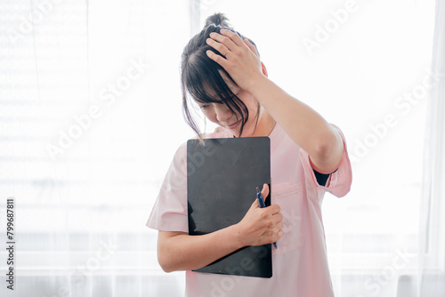 頭を抱える若い医療系女性 photo