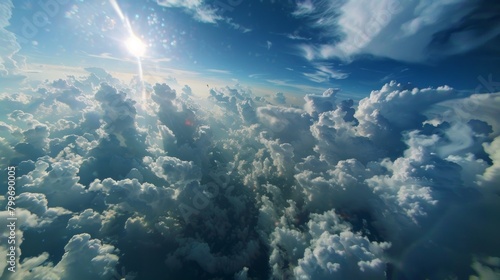 The sun can be seen shining brightly above a layer of fluffy clouds in the sky. The rays of sunlight are casting a warm glow on the cloud tops.