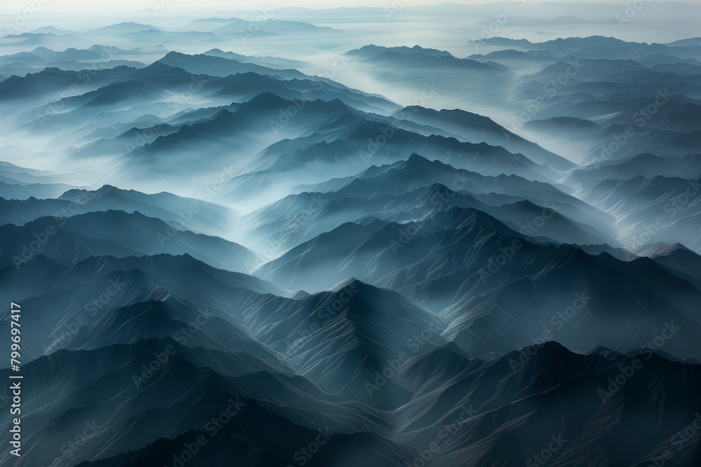 Aerial view of layered patterns of mountain ridges receding into the distance, with their alternating light and shadow creating a minimalist composition. Aerial view of layered patterns of mountain ridges receding into the distance, with their alternating light and shadow creating a minimalist composition.