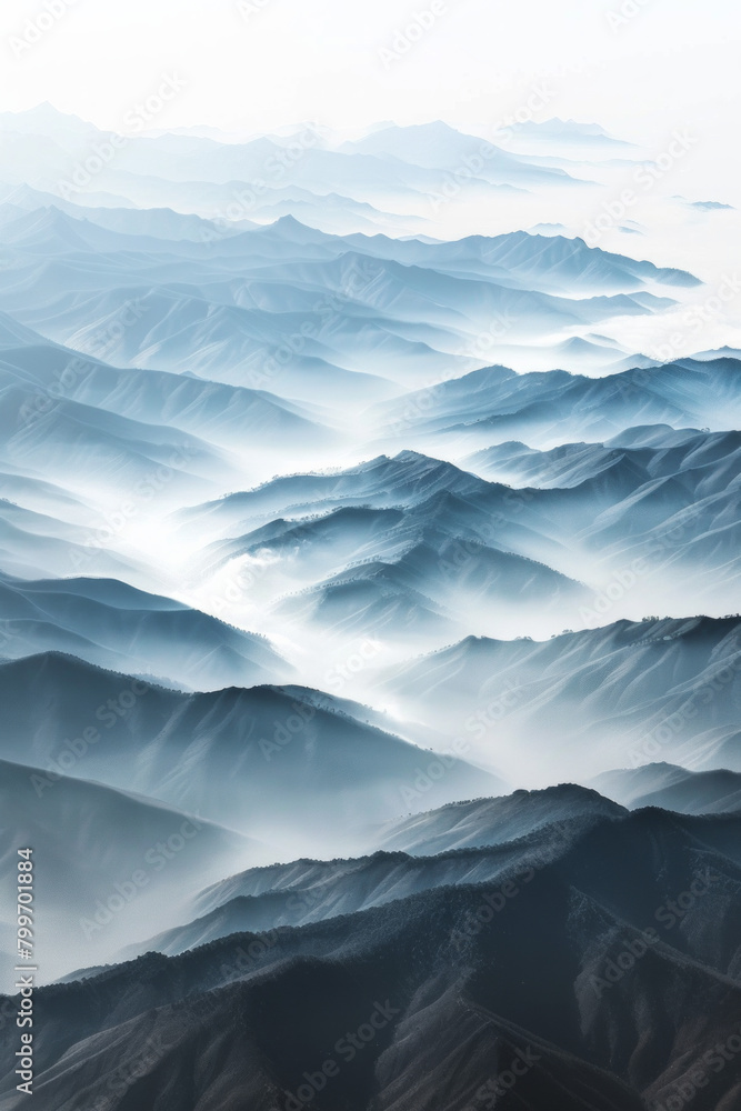 Aerial view of layered patterns of mountain ridges receding into the distance, with their alternating light and shadow creating a minimalist composition. Aerial view of layered patterns of mountain ridges receding into the distance, with their alternating light and shadow creating a minimalist composition.