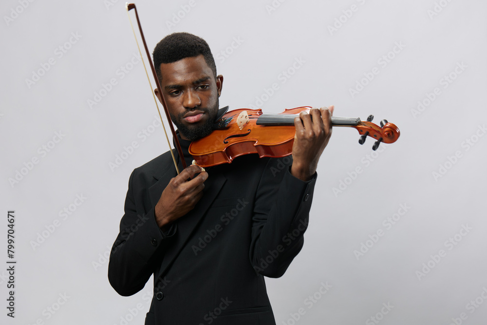 Talented African American man in elegant suit holding a violin isolated on white background Talented African American man in elegant suit holding a violin isolated on white background