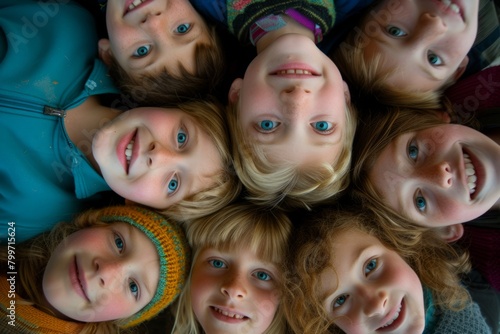 Top view of group of kids lying in circle and looking at camera