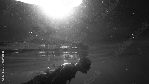 black and white footage of a spear fisher who catching fish in polluted marine  water photo