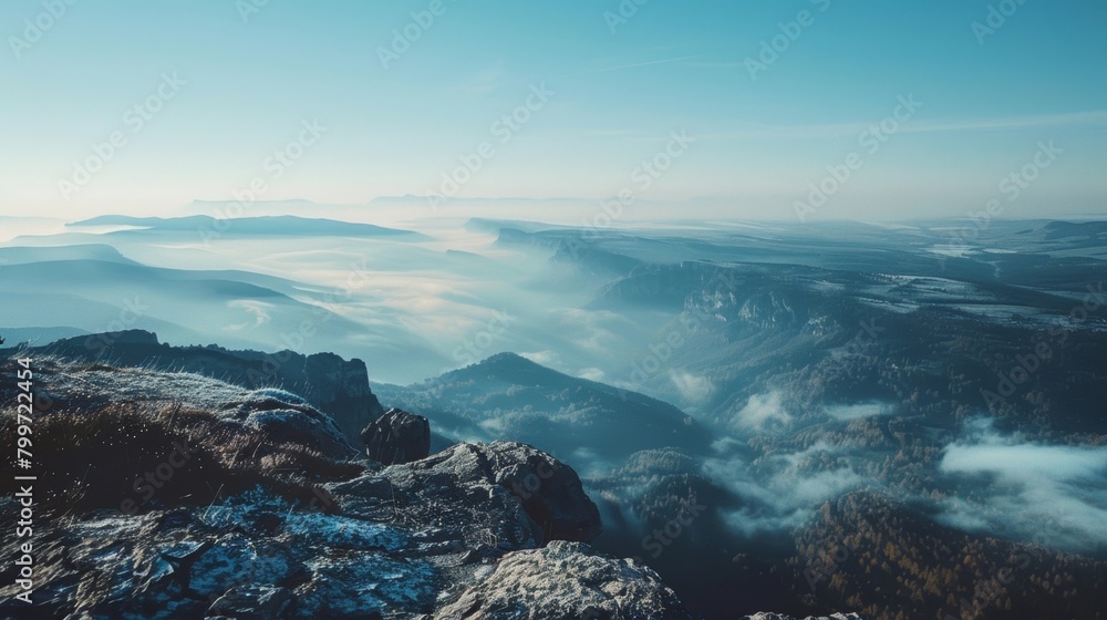 The view from the top of a mountain, showing vast valleys, rocky peaks, winding trails, distant forests, and a clear blue sky. The view from the top of a mountain, showing vast valleys, rocky peaks, winding trails, distant forests, and a clear blue sky.