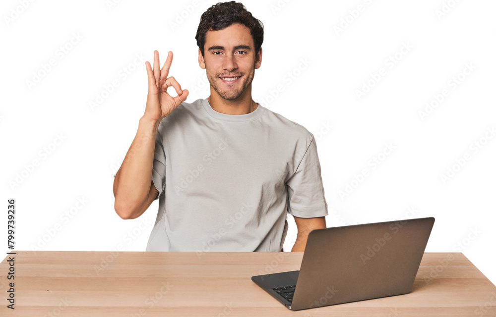Hispanic young man working on laptop cheerful and confident showing ok gesture. Hispanic young man working on laptop cheerful and confident showing ok gesture.