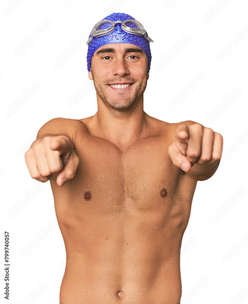 Young Hispanic man with swim gear cheerful smiles pointing to front.