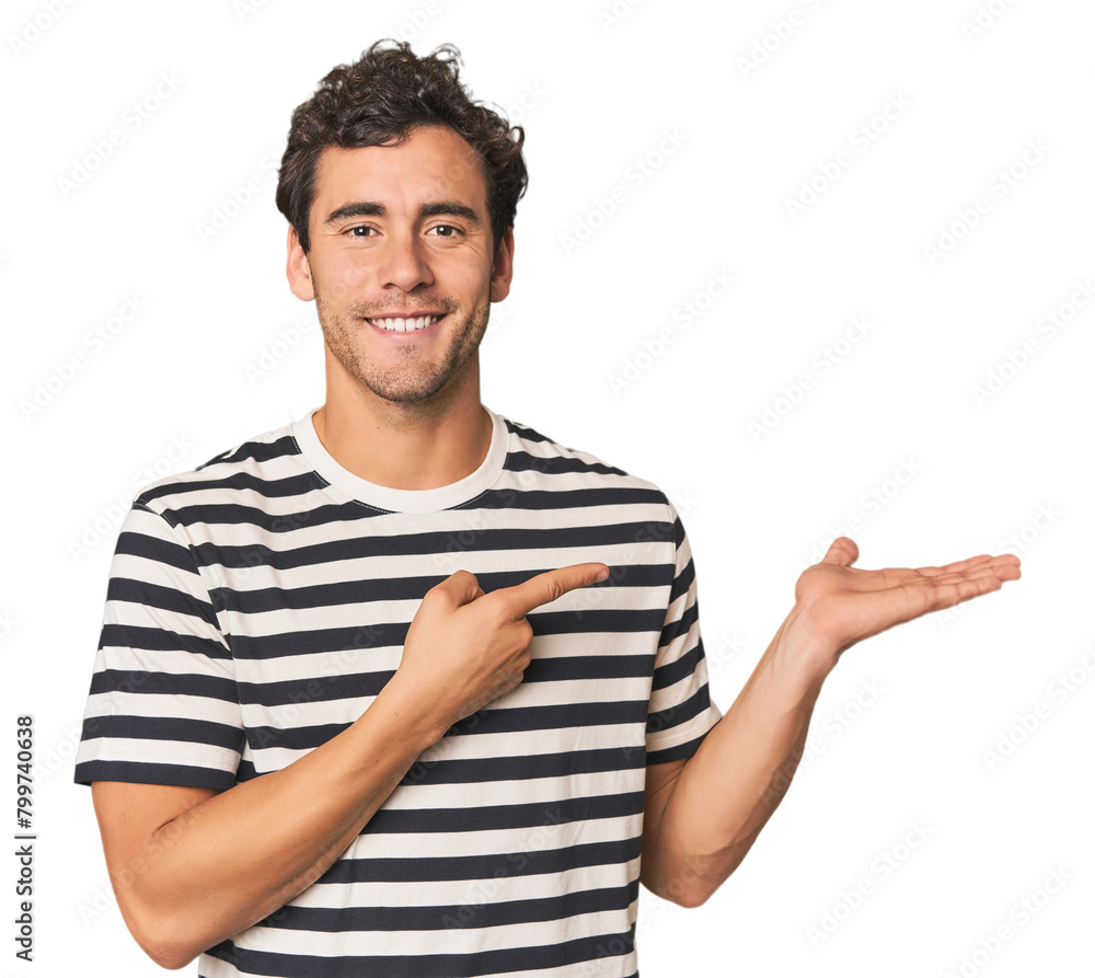 Young Hispanic man in studio excited holding a copy space on palm. Young Hispanic man in studio excited holding a copy space on palm.