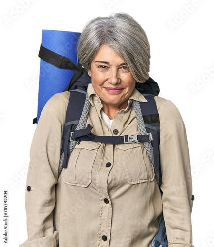 Caucasian mid-age female with hiking gear laughs and closes eyes, feels relaxed and happy. © Asier