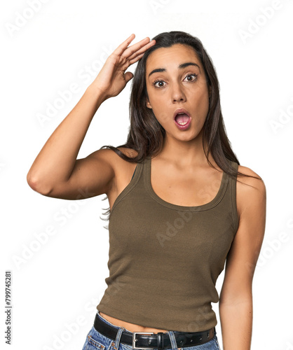 Hispanic young woman shouts loud, keeps eyes opened and hands tense.