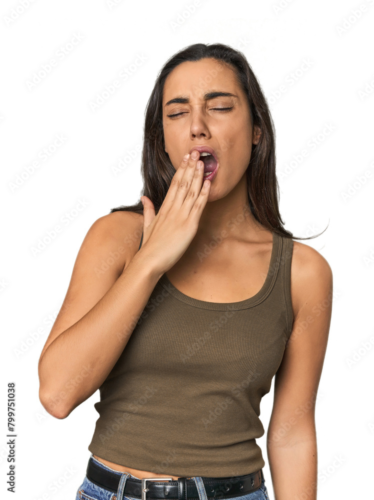 Hispanic young woman yawning showing a tired gesture covering mouth with hand. Hispanic young woman yawning showing a tired gesture covering mouth with hand.