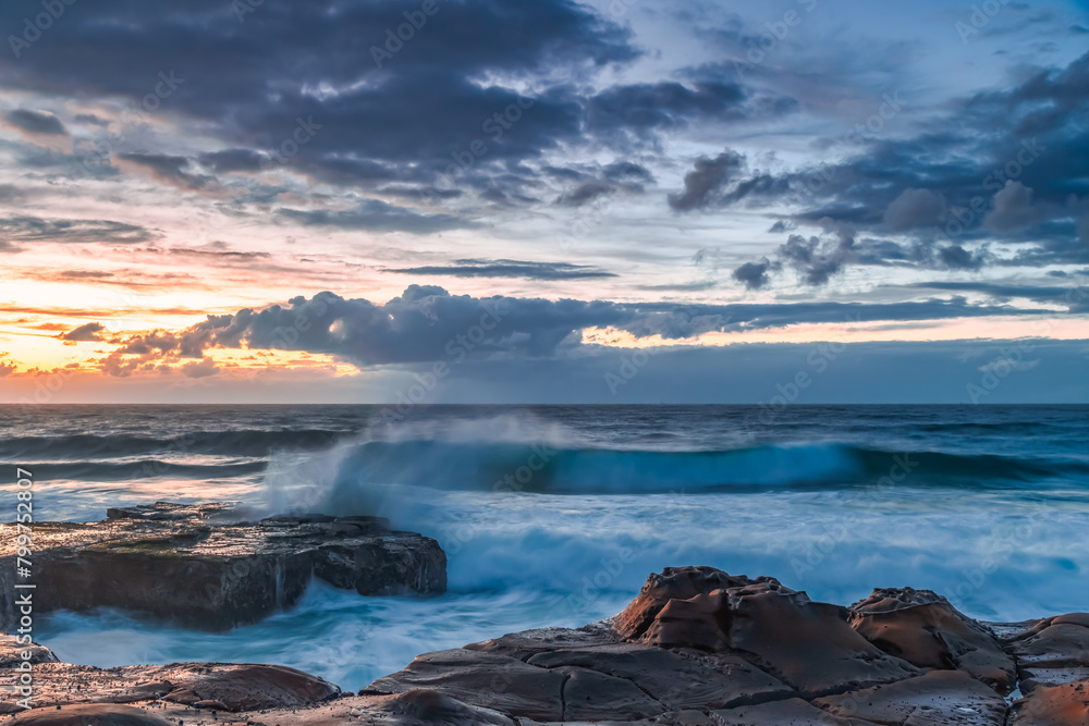 Sunrise, sea, waves, clouds and tessellated rock platform