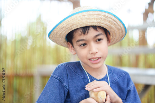 Happy family sibling enjoying summer outdoors with their baby chick in the farm