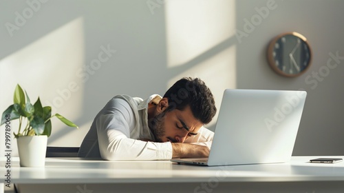 Tired at work and falling asleep man at his workplace in the office. A man fell asleep on the desk near laptop. Professional burnout, work without rest, workaholism photo