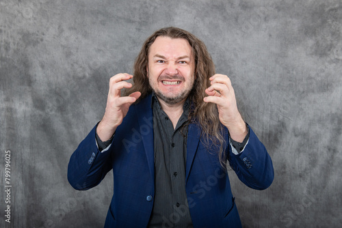 Professional businessman with long hair in blue suit striking various confident poses