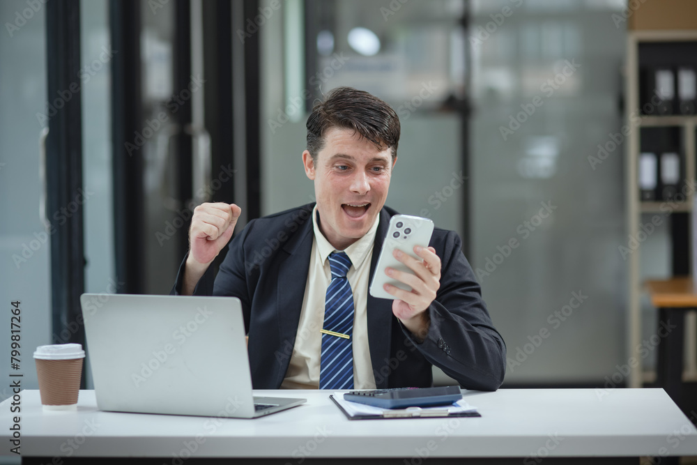 Businessman with smartphone and laptop and analyzing a chart while working in the office, Business and financial concept. Businessman with smartphone and laptop and analyzing a chart while working in the office, Business and financial concept.