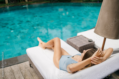 Summer day life women relaxing next to the luxury sunbathing pool on the beach of the outdoor hotel resort, focus on hands, Summer concept. Baner. copy space.