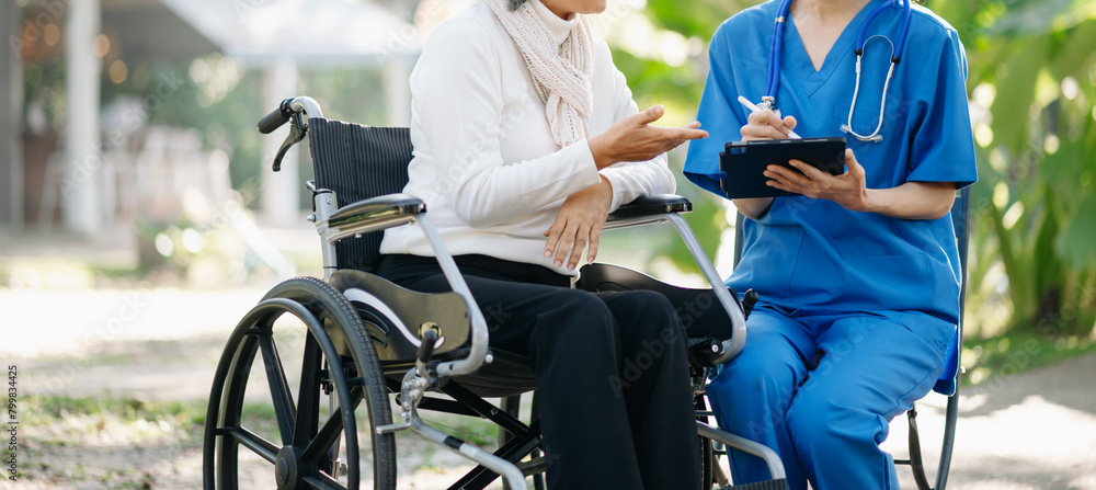 Obraz premium Elderly asian senior man on wheelchair with Asian careful caregiver. Nursing home hospital garden concept are walking in the garden.
