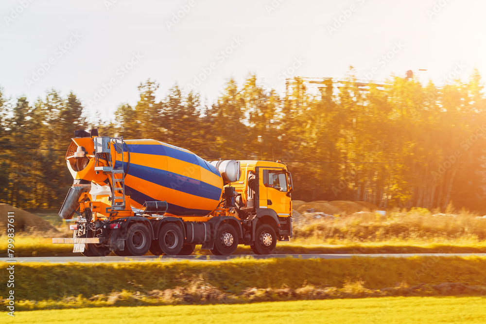 Yellow Mixer Vehicle in Action Transporting Essential Building Material on Road Yellow Mixer Vehicle in Action Transporting Essential Building Material on Road