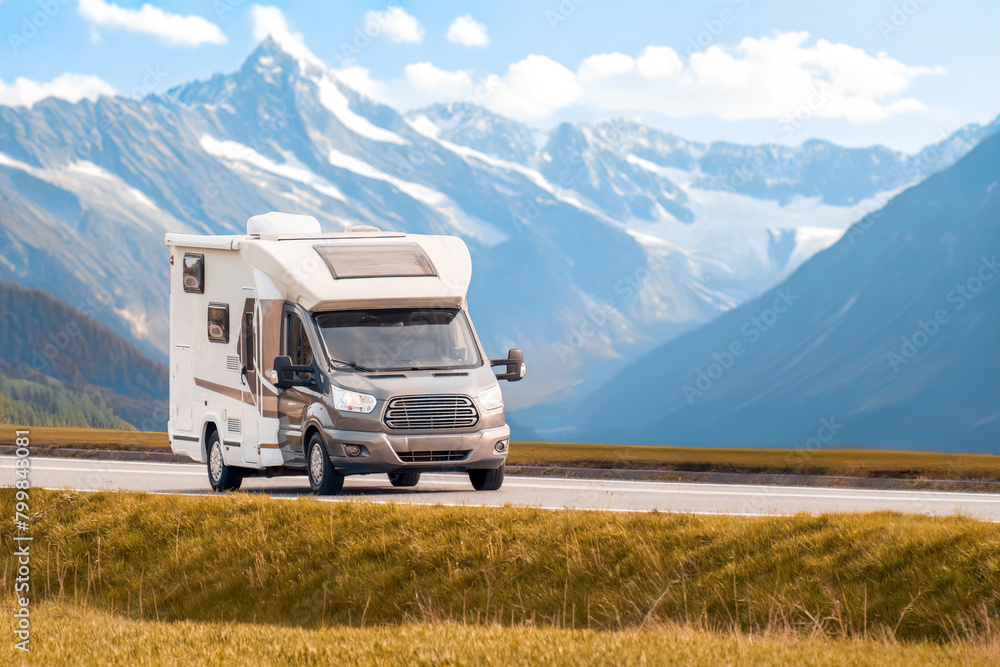Rv travels on a highway with majestic mountains in the background