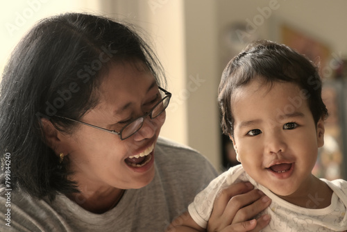 Happy expression of a woman playing with her little baby boy