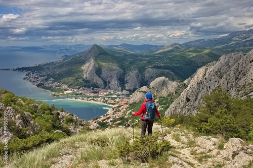Rear view of senior woman hiking on the mountain with beautiful view on the Adriatic coast