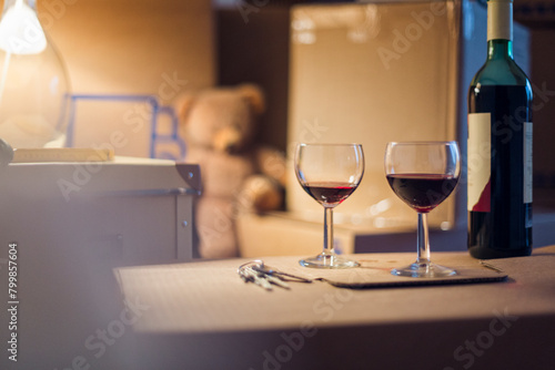 Wine bottle and glasses on cardboard box in a new home photo