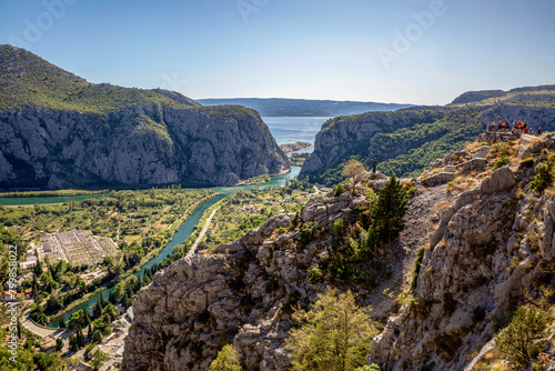 Croatia, Dalmatia, Omis, Settlement situated at forested bank of Cetina river in summer photo