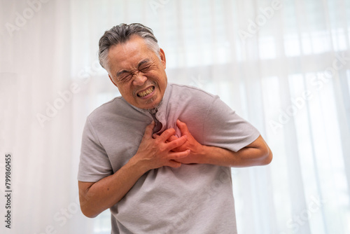 Senior asian adult elderly man with chest pain suffering from heart attack, health and medical, heart health, heart attack, world heart day, cardiovascular disease.insurance and hospital concept