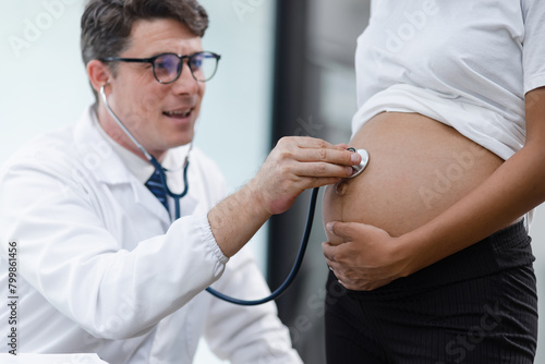 Male doctor examining a pregnant African American woman at the hospital.