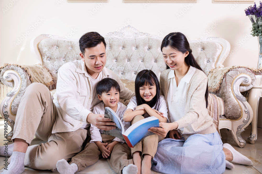 A family of four reading and playing together in the living room A family of four reading and playing together in the living room
